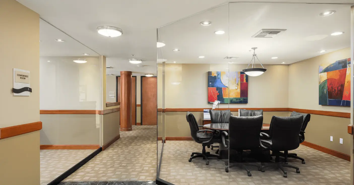 Small boardroom with round table and black chairs
