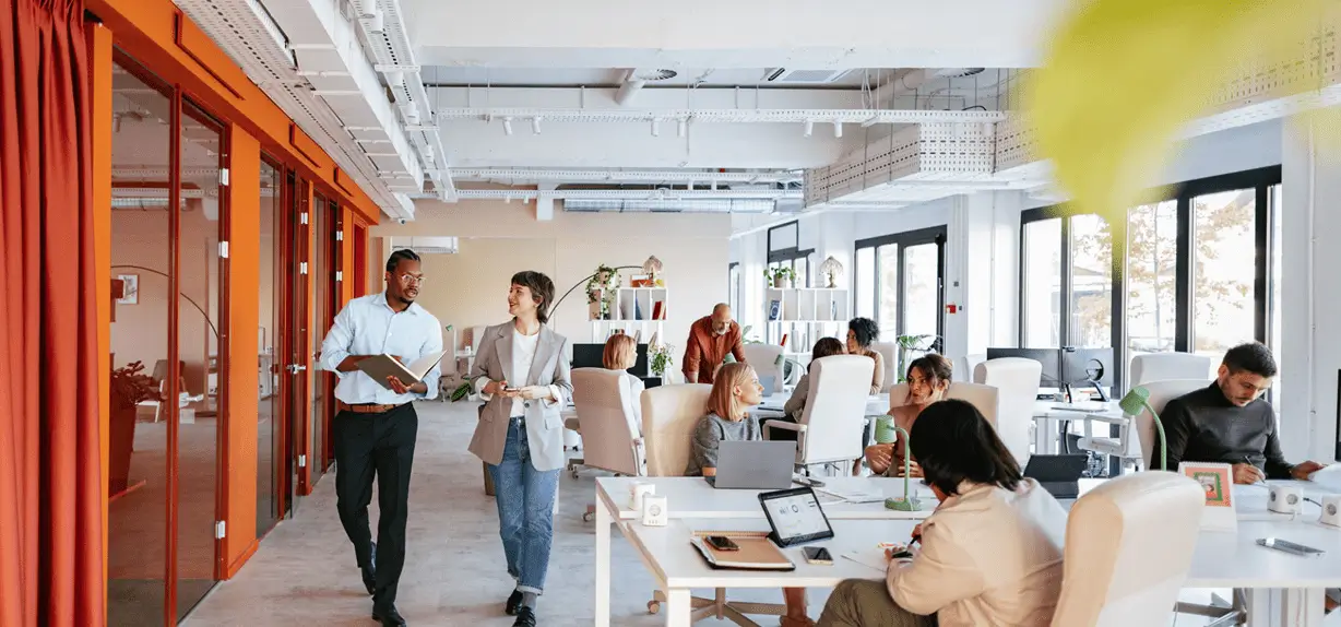 Two coworkers walking past open-plan desks
